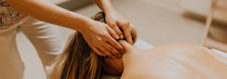 Massoterapista esegue un massaggio cervicale per alleviare tensioni muscolari nella zona di collo e spalle.